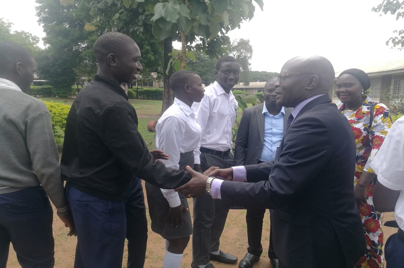 Justice Byabakama interacts with some students shortly after the meeting on Friday 