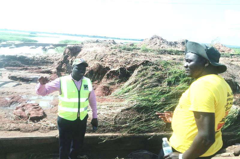 Eng. Lukala speaks to Omito (R) during the inspection of the affected section of the road on Tuesday. Photo Credit_ Andrew Cohen Amvesi