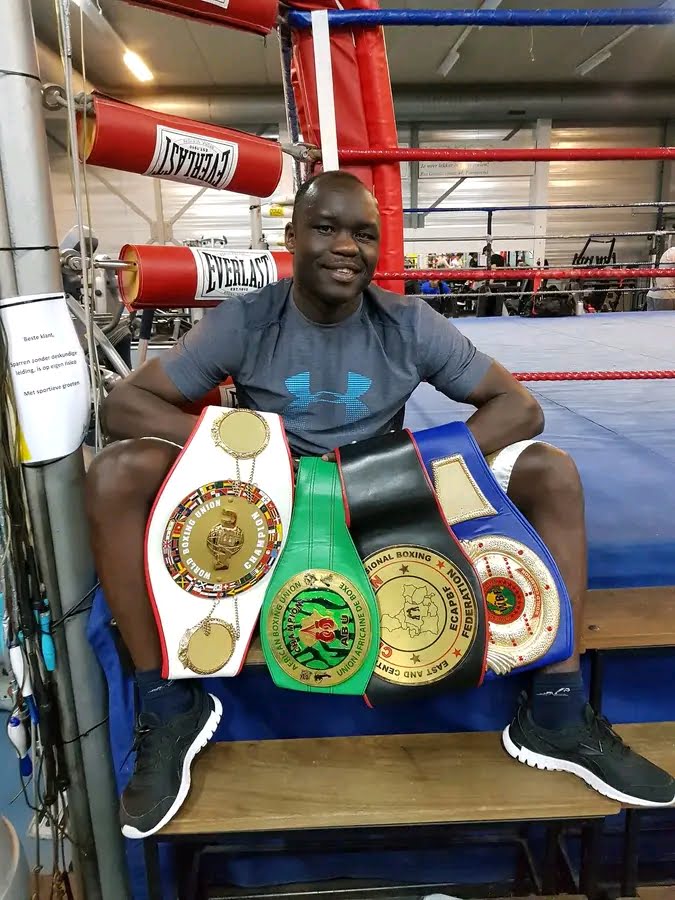 Farouk Daku Malingumu showing his boxing belts