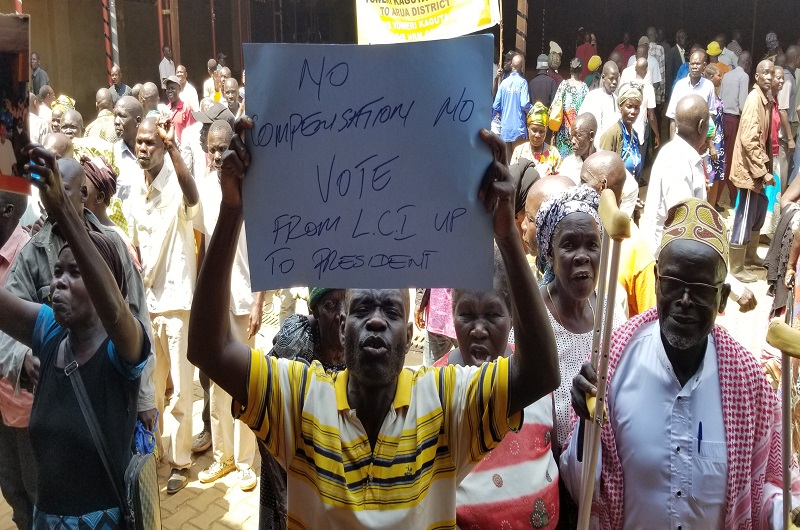 One of the aggrieved Kony war victims in WestNile carries a placard during their meeting on Saturday