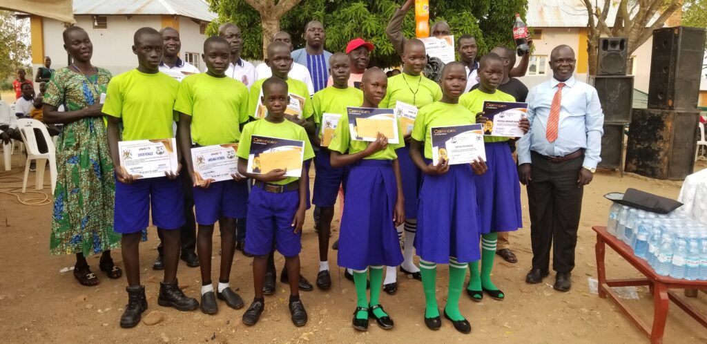 PLE Stars and the best debaters of Nyarakua PS pose for a group photo with their teachers and district officials on Sunday