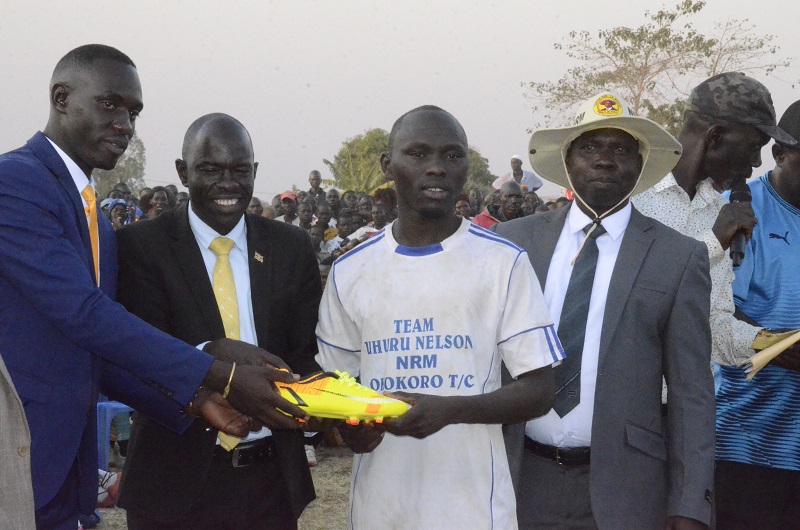 Uhuru (L) hands over a boot to the plaer of the match on Thursday