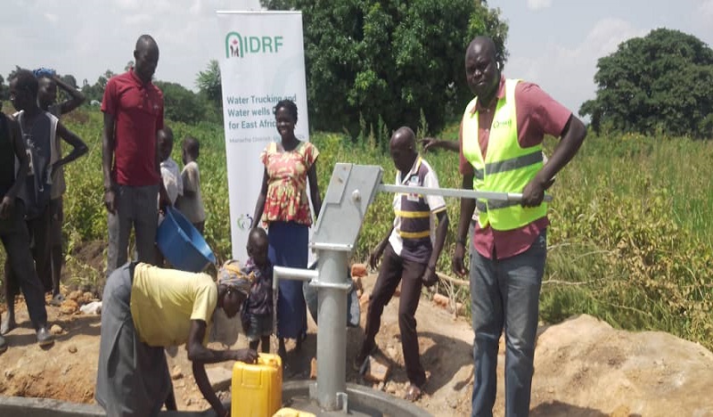 A staff of PHASE pumps water for residents at one of the newly constructed shallow water well in Paranga sub-county, Maracha East