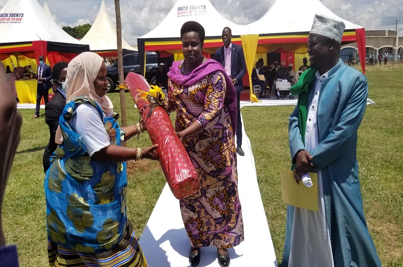 H.E Alupo receives a gift from a Muslim at Arua primary school ground as Sheik Shaban Abu Jafar looks on