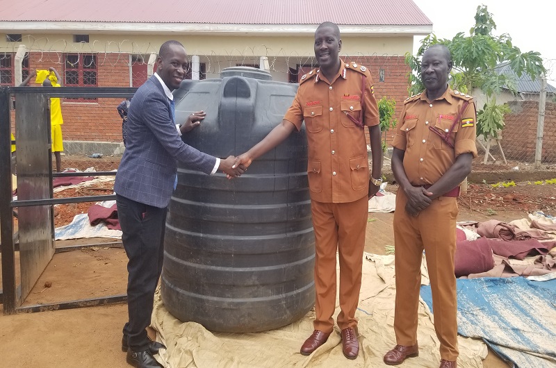 Leni Ndori greets Arima (L) in excitement after receiving the 2000-litre capacity tank as Alidro (R) looks on. Photo Credit Andrew Cohen Amvesi