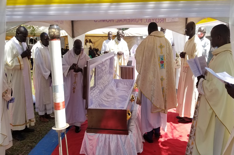 Priests blessing the casket containing Achidri Benard's remains before burial on Wednesday