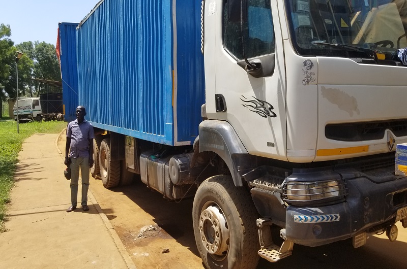 Ramandan Adaku stands next to another Arua truck of fish being held at Elegu shortly after an interview