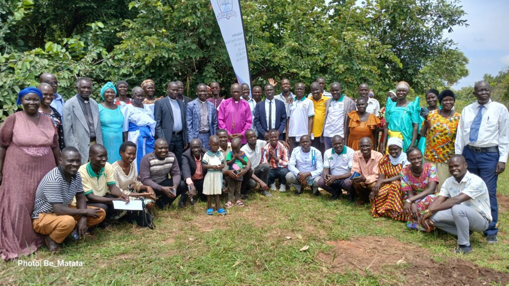 Bishop Andaku poses in a group photo with team in Yumbe and Household and Community Transformation