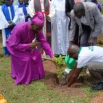 Bishop Collins Andaku planting a tree as a sign of stewardship in Aringa yesterday