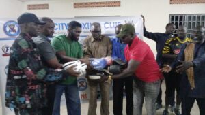 Andama Daku (in green) handing over the assorted boxing materials to Arua City Boxing Club