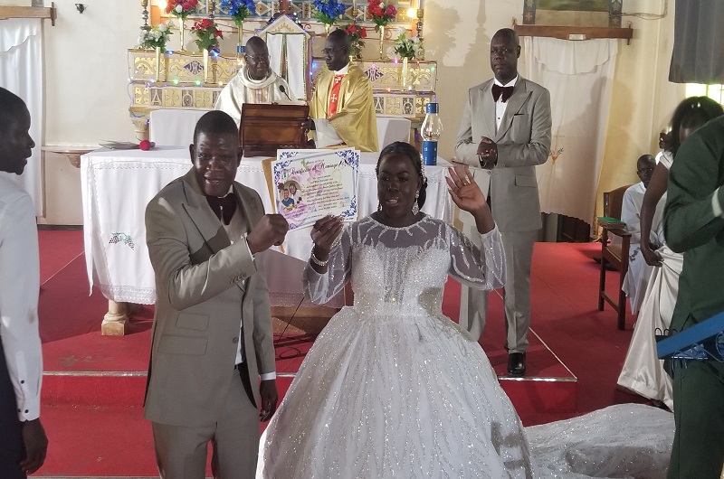 Angelo Embama and Margaret Ajua displaying their wedding certificate before the congregation in Christ the King Church Arua on Saturday. Photo Credit, Andrew Cohen Amvesi