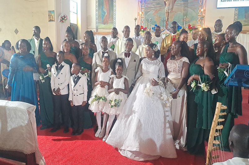 The newly wedded couple posses for a group photo with Priests and some witnesses in Christ the King Church Arua on Saturday. Photo Credit, Andrew Cohen Amvesi