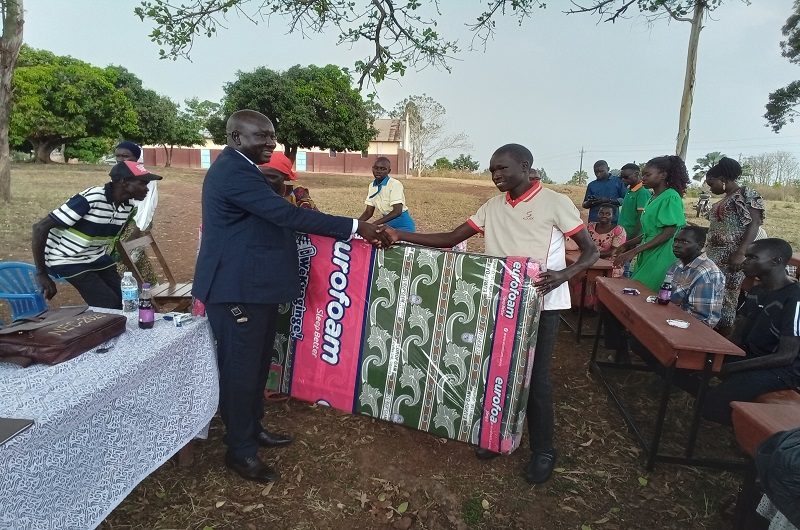 Victor Ezamile receives a mattress from Banya at Anyakalio PS on Thursday. Photo Credit; Andrew Cohen Amvesi