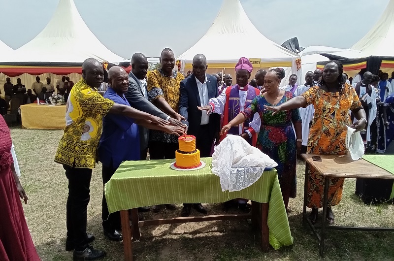Family members and local leaders join Bishop Andaku and Dramviku in cutting a cake during the thanks giving ceremony on Saturday. Photo Credit; Andrew Cohen Amvesi