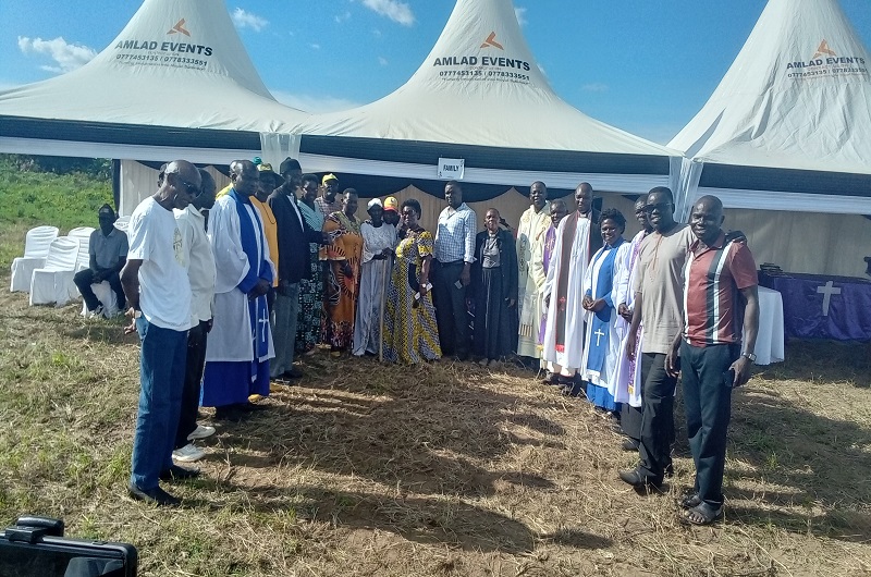 Clergy and local leaders join Late Edemaga's widow in a group photo on Saturday. Photo Credit; Andrew Cohen Amvesi