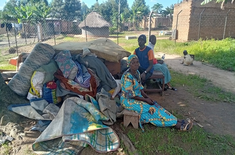 Candiru seated with her two children shortly after the May 11 forceful eviction. At the background is the fenced plot from which she was evicted. Photo Credit; Andrew Cohen Amvesi