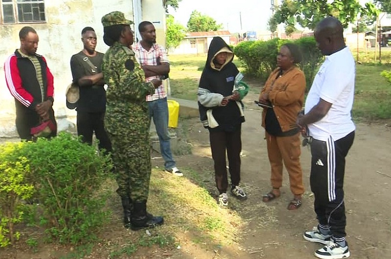 Achile (R) with some security personnel after intercepting Congolese nationals in Pakwach recently