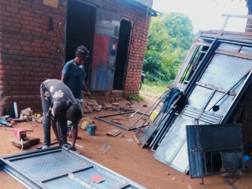 Instructor at the workshop welding a metalic door