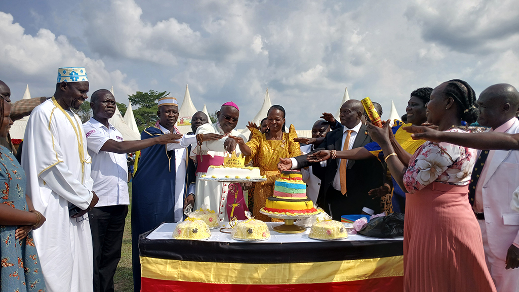 Hon. Jennifer Driwaru accompanied by Bishop Odoki in cutting cake Photo Credit Matata Bezamin