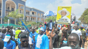 Hon. Muzaid Khemis in a road procession, with a young man carrying President Museveni's portrait. Photo by Matata Benzamin