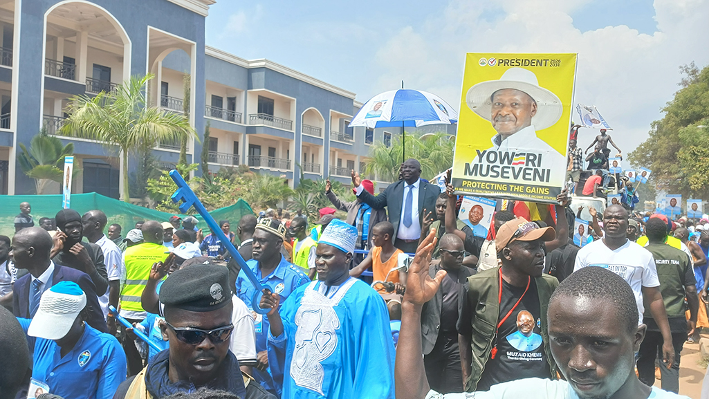 Hon. Muzaid Khemis in a road procession, with a young man carrying President Museveni's portrait. Photo by Matata Benzamin