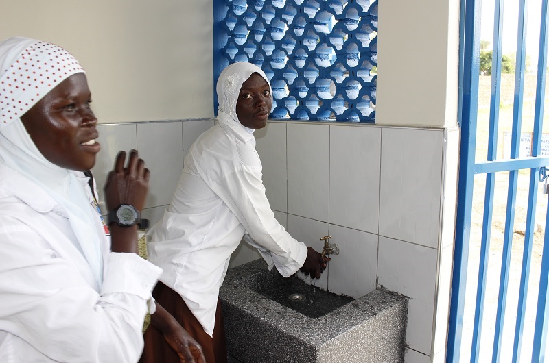 A female student of Yumbe SS washes hands in the newly constructed Girls' VIP Latrine as her colleague looked on during the commissioning ceremony on Tuesday.