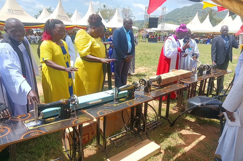 Bishop Andaku praying over some of the Sewing machines purchased and donated by MP Eric Dramviku