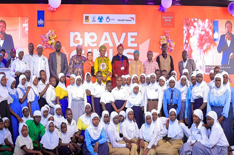 Hajjat Medina (in yellow NRM dress) posses for a group photo with students and officials during the function in Yumbe district