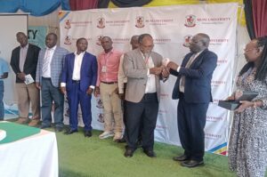 Prof. Kajobe handing over an accolade to one of the best research finding presenters on Thursday.