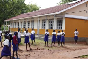 Pupils of Odike primary school posing for a photo moment in front of one of the the newly constructed classroom blocks at their school under EU-WASH project.