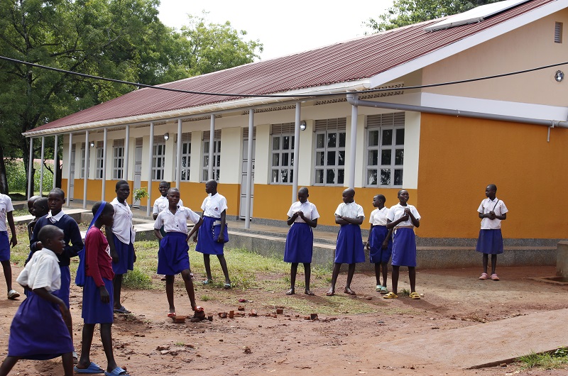 Pupils of Odike primary school posing for a photo moment in front of one of the the newly constructed classroom blocks at their school under EU-WASH project.